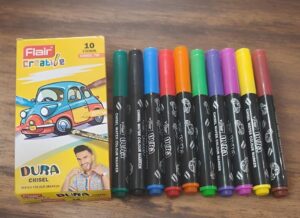 Set of ten Flair Create chisel-tip water color markers in assorted colors beside a yellow branded box on a wooden surface.
