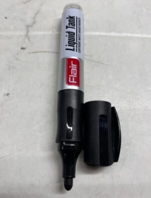 Marker pen with a silver body and black cap, labeled 'Flair' and 'Liquid Tank', lying on a light, marble-like surface.