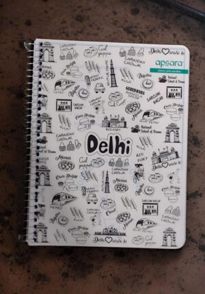Spiral notebook cover covered with Delhi-themed doodles—monuments, foods, and the word 'Delhi' at center.