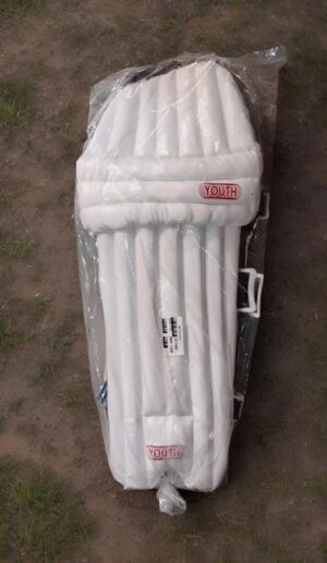 White inflatable air mattress still in its clear plastic packaging, labeled 'Youth', lying on a dirt ground.