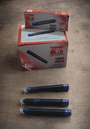 Blue ink cartridges and FigO brand boxes on a wooden table, with three blue cartridges lined up below the boxes.