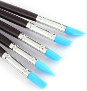 Five blue-tipped markers with brown barrels arranged diagonally on a white surface.
