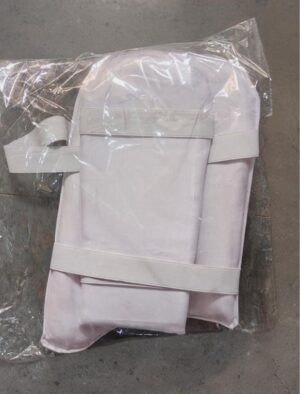 Folded light-pink backpack with wide straps, sealed in clear plastic on a concrete floor over there.