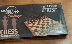 Product image: wooden chess set in a box with a chessboard and pieces displayed on the packaging.