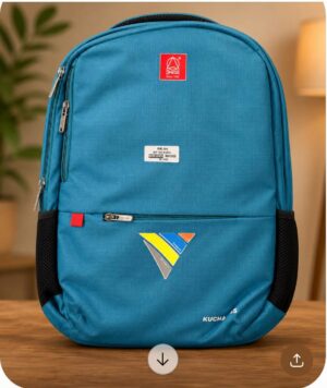 Blue backpack standing on a wooden table indoors, with zippered front pocket, red logo patch, and colorful geometric sticker on the lower front.