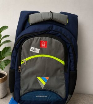 Navy and gray backpack with a bright neon-yellow zipper, standing upright next to a potted plant.