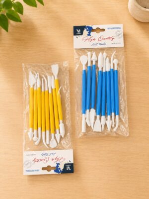 Two packs of small sculpting tools with yellow and blue handles in clear plastic bags on a wooden table.