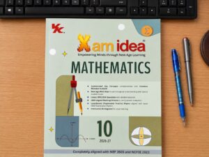 Mathematics textbook on a wooden desk with a black keyboard above and blue/gray pens to the right.