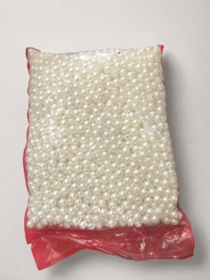 Bag of small white plastic pearl beads filling a red resealable bag, ready for crafts or jewelry making.
