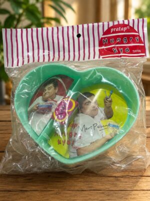 Heart-shaped turquoise plastic plate and utensils in a clear bag with pink-striped top; label shows a cartoon man.
