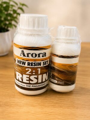 Two bottles of Arora resin kit on a wooden table, labeled 'NEW RESIN SET 2:1 RESIN' and wrapped in plastic wrap.