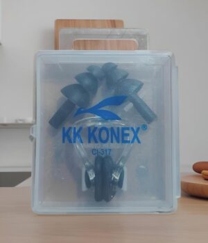 Clear plastic storage box with a blue KK KONEX logo visible on the front, contents visible inside, placed on a wooden surface.