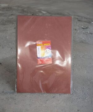 Brown portfolio box with a small 'Pastel Sheets' label, resting on a gravel surface.
