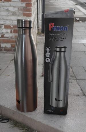 Stainless steel sports water bottle on a sidewalk beside its black Pexon packaging box.