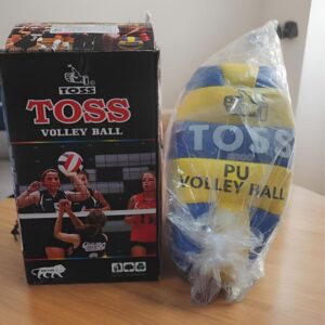 Boxed Toss volleyball set with players on the front, placed next to a blue-yellow PU volleyball in plastic wrap on a wooden table.