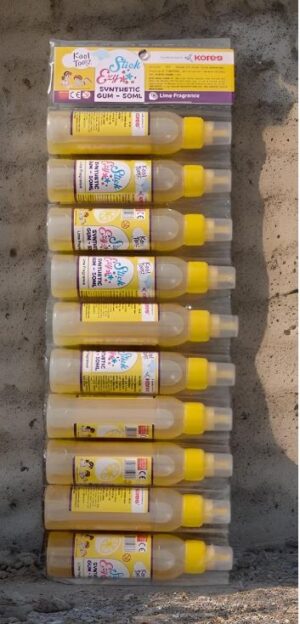 Row of white glue bottles with yellow caps lined up in a vertical display against a wall, ready for crafts.