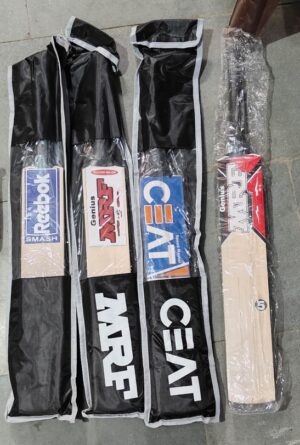 Four black snowboard bags with light-colored trim laid out on a concrete sidewalk, several boards partially exposed with branding stickers showing on the bags. The rightmost board appears wrapped in plastic.