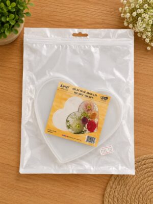 Heart-shaped silicone mould inside a clear plastic bag with product card reading 'Silicone Mould Heart Shape' on a wooden table.