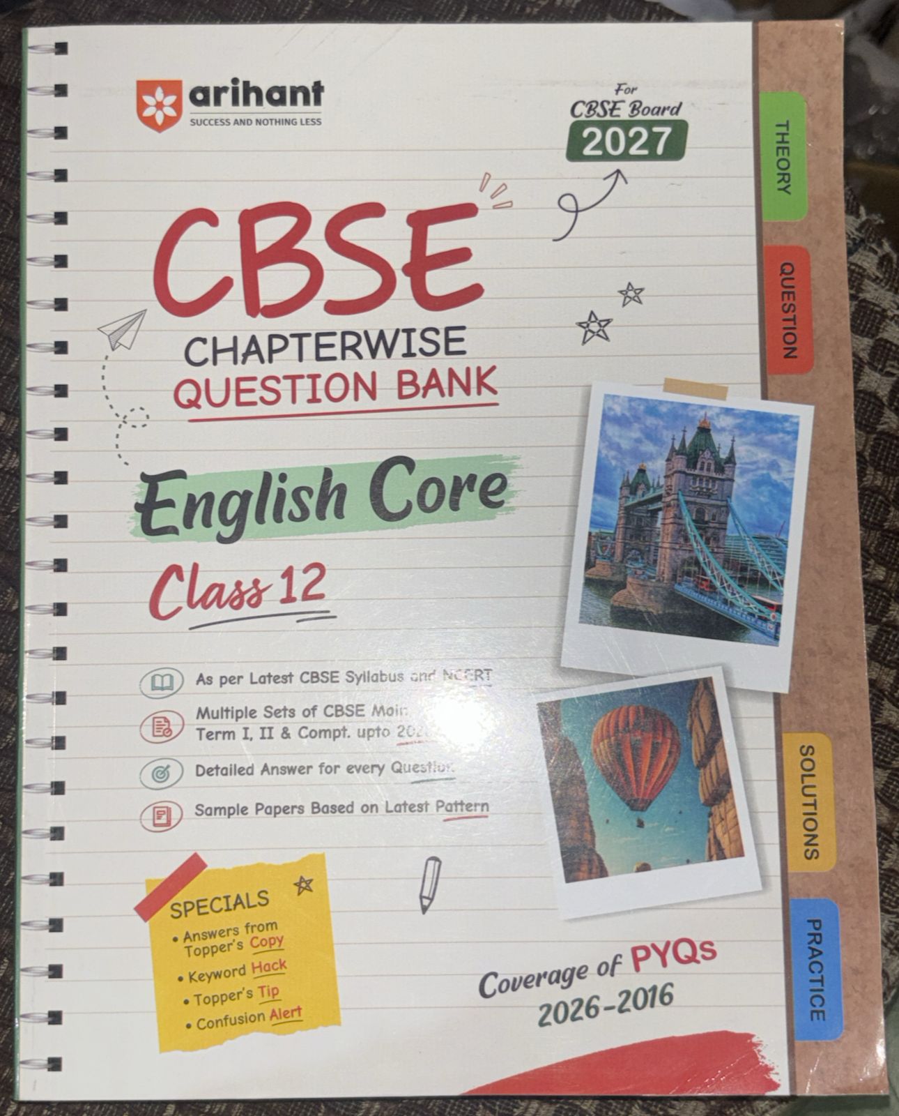 Cover of a CBSE English Core Class 12 question bank notebook with notes, tabs for Theory/Questions, and postcards of landmarks attached (Tower Bridge image).