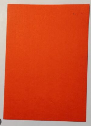 Bright orange rectangular sheet of paper resting on a light surface, viewed from above.