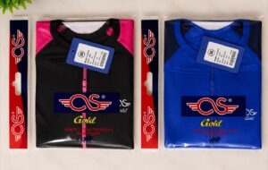Two packaged casual jackets side by side: left is black with pink zipper, right is blue with matching zipper, both bearing a CS logo and Gold branding in plastic wraps