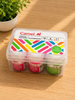 Camel brand acrylic colours set in a clear plastic case on a wooden table, with a green plant in the background.