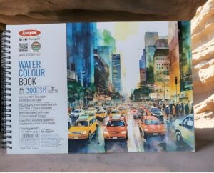 Watercolour book cover showing a colorful urban street scene with taxis and tall buildings, left panel with brand and specs like A4 size and 12 sheets.