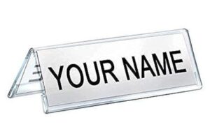 Transparent desk name plate on a folded stand with the placeholder text 'YOUR NAME'.