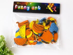 Colorful fruit-shaped foam cutouts (banana, lemon, orange, pear, etc.) in a clear bag labeled 'Funny Art' for crafts or kids' activities