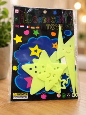 Neon yellow star-shaped foam pieces placed over a black 'Fluorescent Toys' package with colorful stars and shapes.