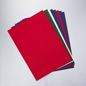 Stack of colorful paper sheets fanned out on a light surface, with a prominent red sheet in front (colors include red, blue, green, white, and black).