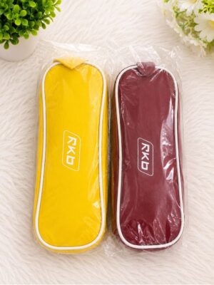 Two zippered pencil cases in yellow and burgundy, still in plastic packaging, placed on a fluffy white surface with green plants nearby.