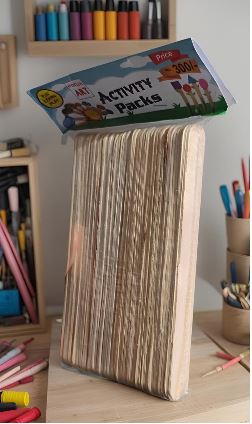 A tall stack of pages standing upright on a desk, with a colorful Activity Packs box balanced on top.