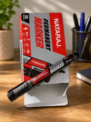 Box of Natraj permanent markers with two black markers laid diagonally on a wooden desk.