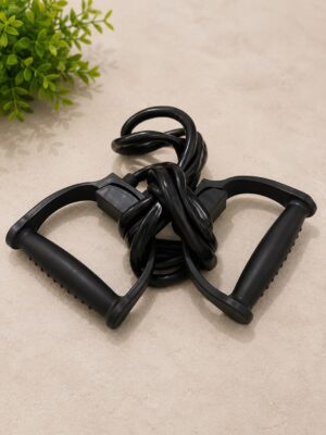 Black jump rope with two textured handles lying on a beige surface, coiled in the center.