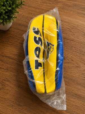 Yellow and blue athletic shoe sealed in clear plastic on a wooden table surface