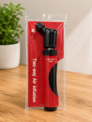 Red packaging for a two-way air inflation pump placed on a wooden surface, with a plant in the background.
